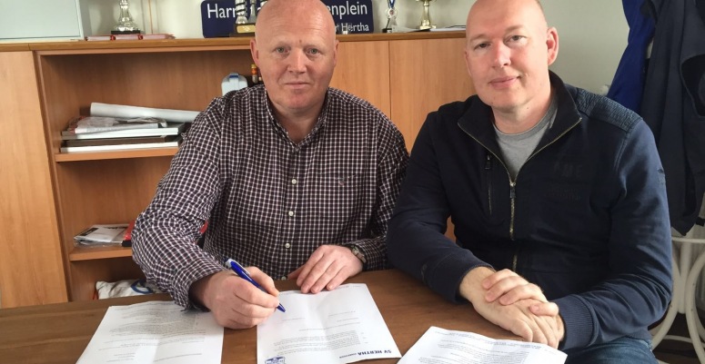 John Dunsbergen (links) tekent zijn contract als nieuwe trainer van SV Hertha. Rechts Michel Klinkhamer (voorzitter SV Hertha).